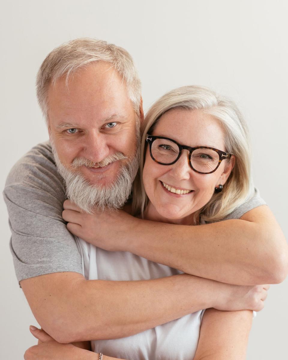 An older couple smiling together at home